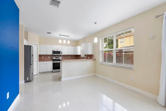 a view of kitchen with kitchen island white cabinets and refrigerator