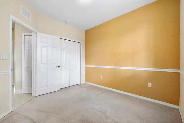 an empty room with a window and a ceiling fan