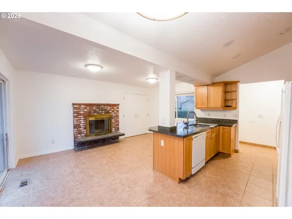 a view of a kitchen with stainless steel appliances a stove top oven