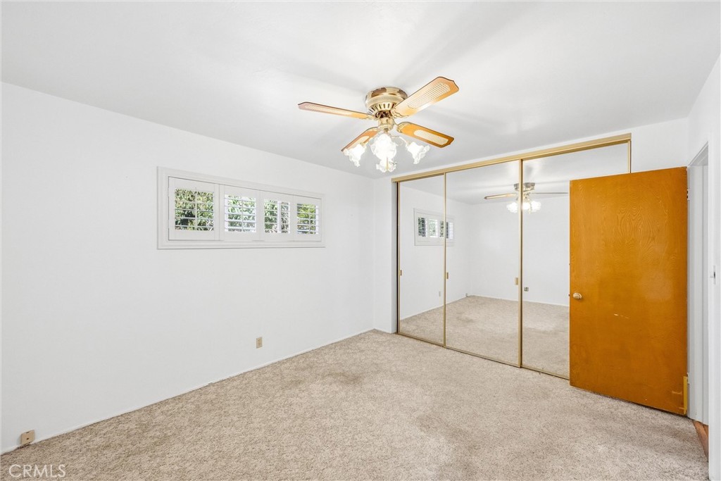 6730 Montclair Drive Riverside, CA 92504 - Photo 30 of 50 Inviting primary bedroom featuring plantation shutters, soft carpeting, and wall-to-wall mirrored closet doors