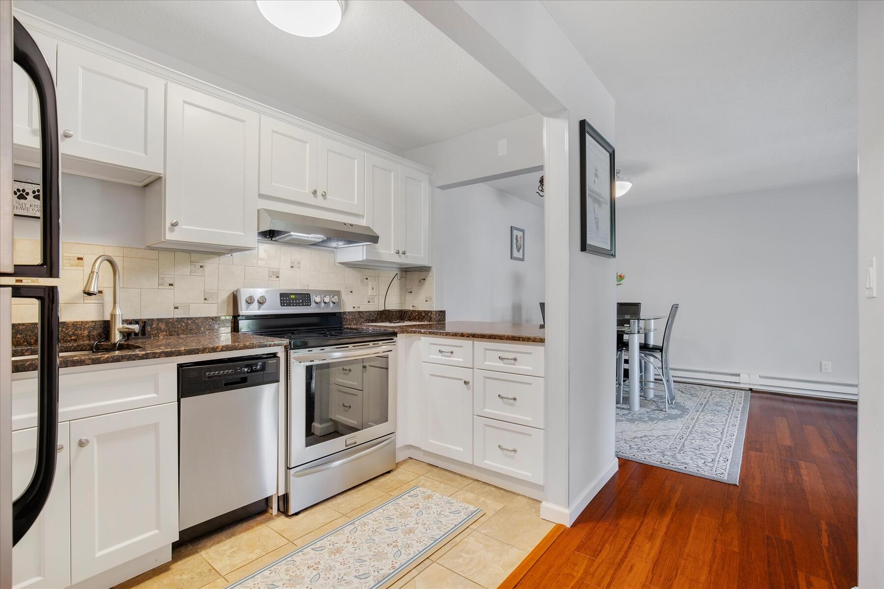 800 Bearses Way, Unit 1EB Hyannis, MA 02601 - Photo 14 of 37 a kitchen with granite countertop white cabinets and white appliances