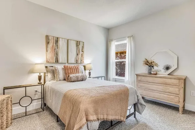 a bedroom with a bed and a painting on the wall