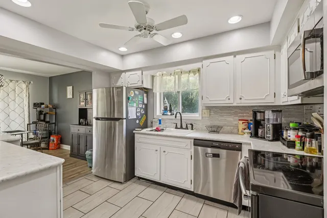 a kitchen with white cabinets and white appliances