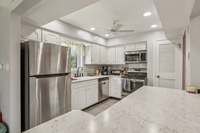 a kitchen with kitchen island a refrigerator sink and cabinets
