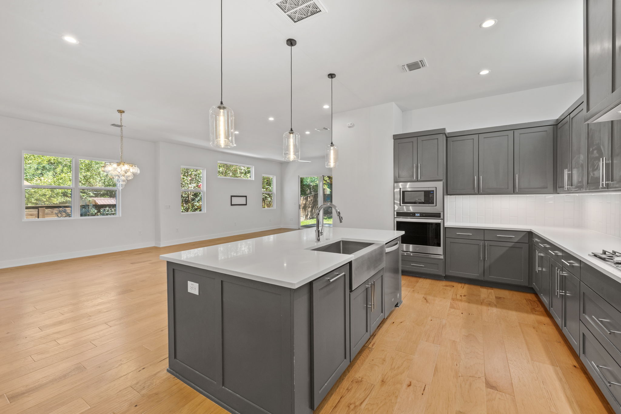 1719 Bunche Road Austin, TX 78721 - Photo 11 of 36 Rich hardwood flooring anchors the modern kitchen, which flows effortlessly into the dining space.