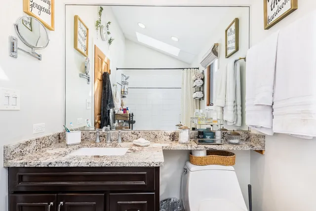 a bathroom with a granite countertop sink and a mirror