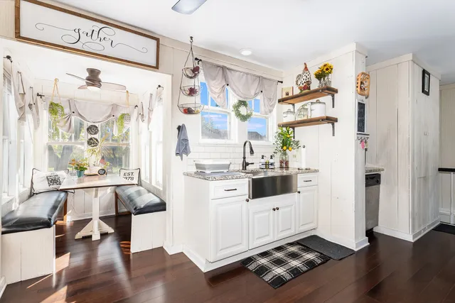 a kitchen with granite countertop a refrigerator and a stove top oven