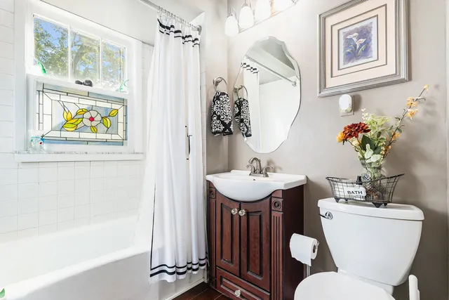a bathroom with a sink mirror and toilet