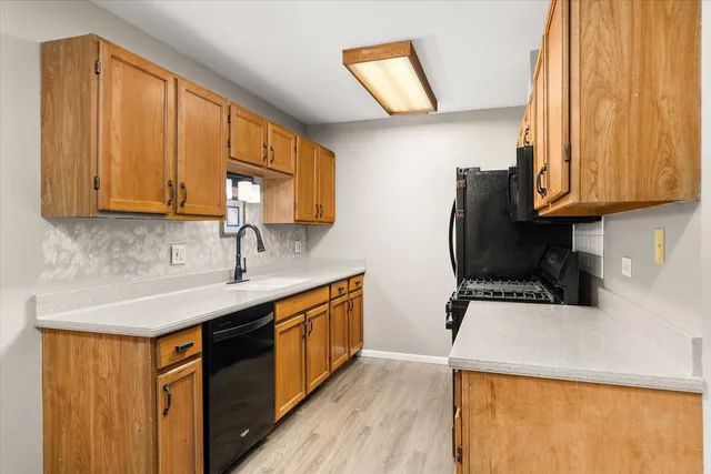 a kitchen with stainless steel appliances wooden cabinets a stove a sink and a refrigerator