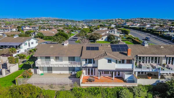 an aerial view of a house with swimming pool and a yard