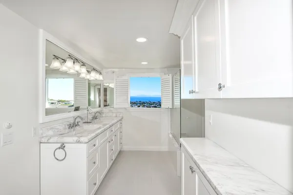 a bathroom with a granite countertop double vanity sink and mirror