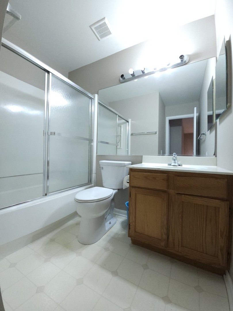 407 Spaulding Road, Unit 407 Bartlett, IL 60103 - Photo 15 of 18 a bathroom with a sink a toilet and a large mirror