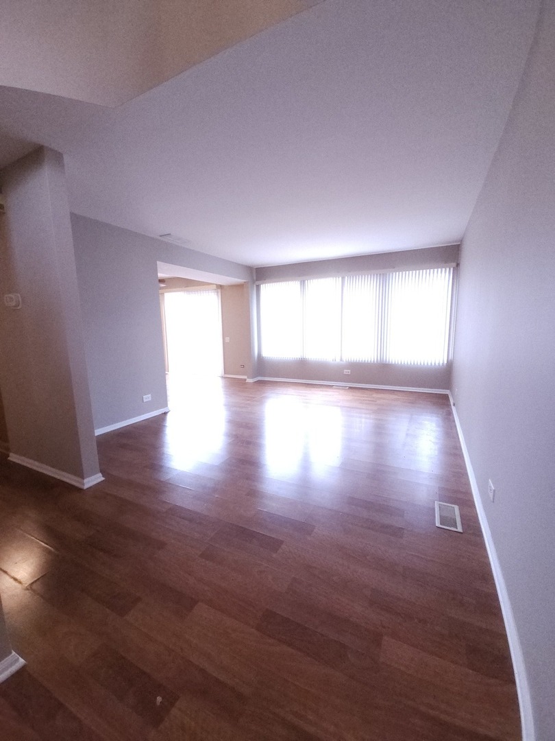 407 Spaulding Road, Unit 407 Bartlett, IL 60103 - Photo 3 of 18 an empty room with wooden floor and windows