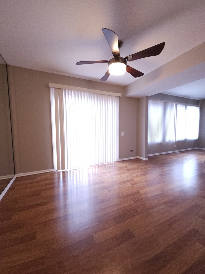 407 Spaulding Road, Unit 407 Bartlett, IL 60103 - Photo 5 of 18 a view of an empty room with window and wooden floor