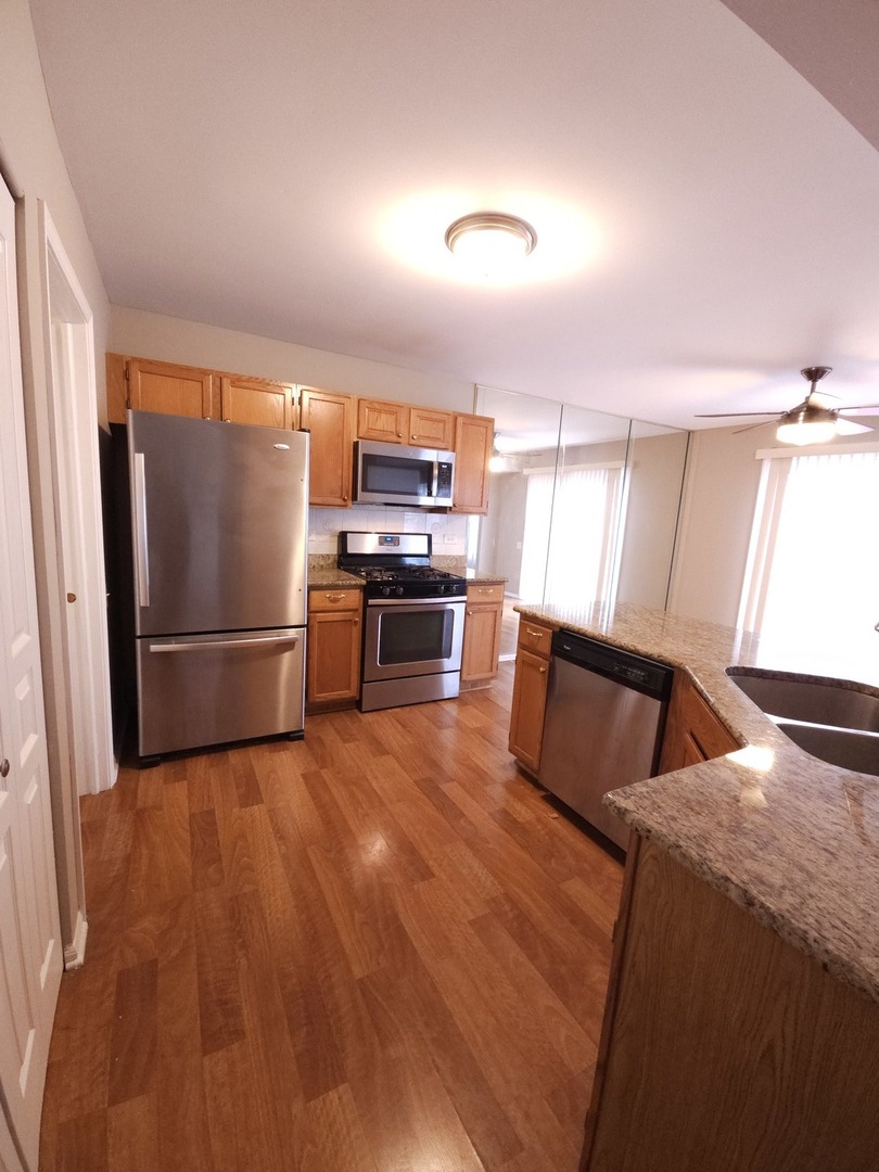 407 Spaulding Road, Unit 407 Bartlett, IL 60103 - Photo 6 of 18 a kitchen with stainless steel appliances granite countertop a refrigerator a stove and a sink