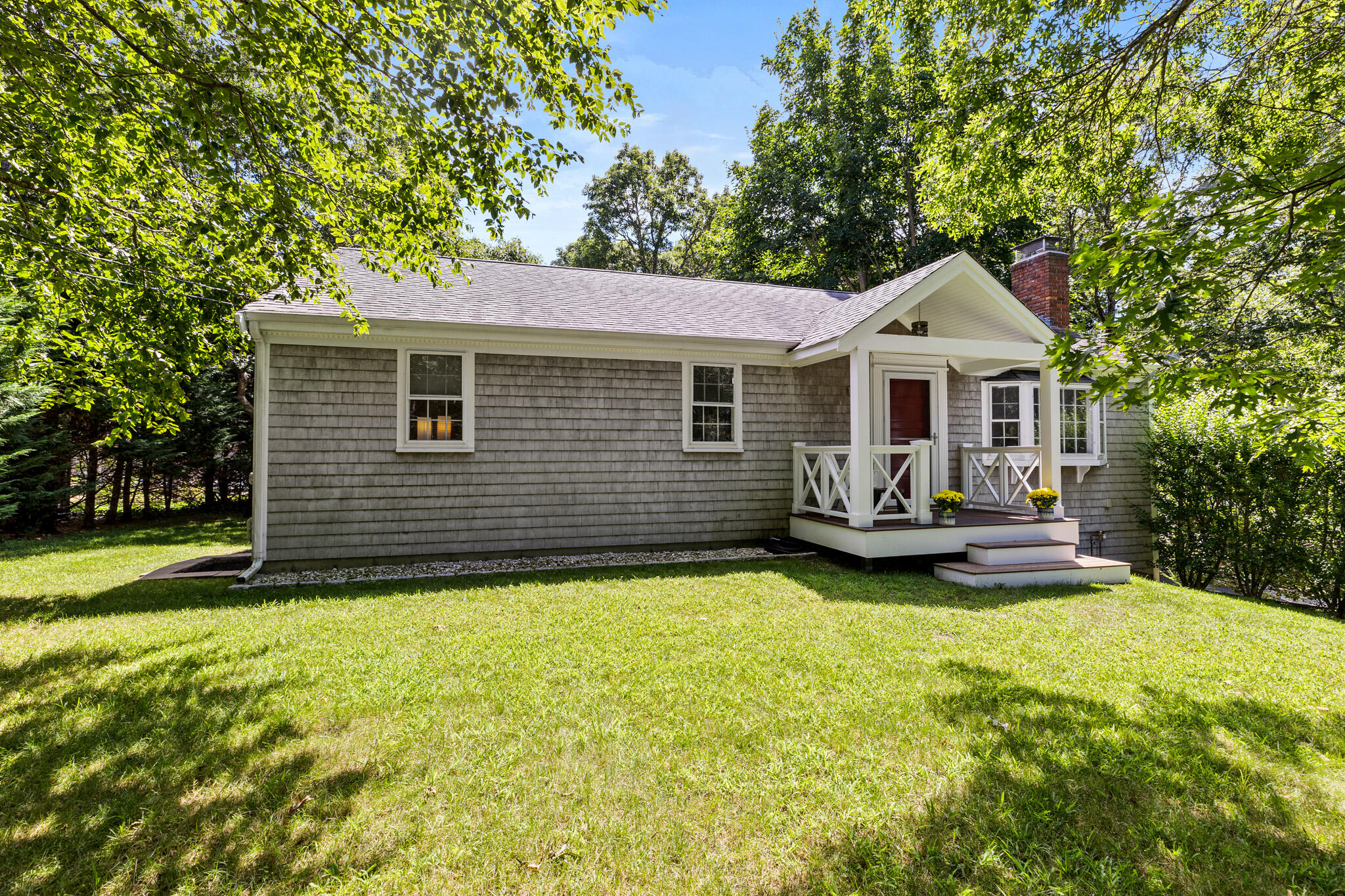 a view of a house with a patio and a yard