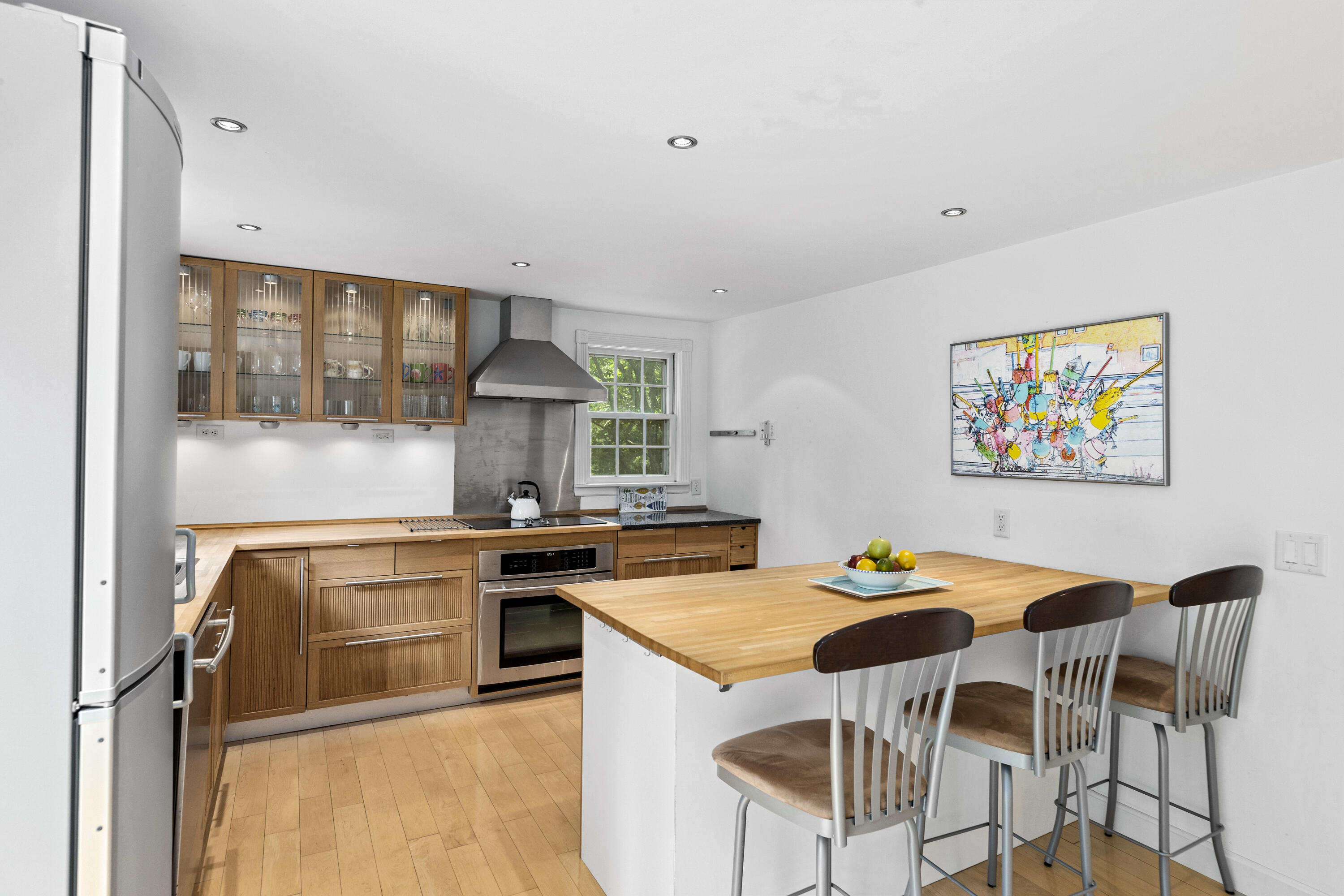 119 Cottonwood Road Harwich, MA 02645 - Photo 9 of 30 a kitchen with stainless steel appliances granite countertop a stove top oven a sink a dining table and chairs with wooden floor