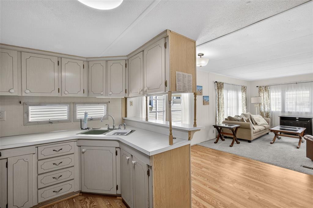 802 Turf Street Venice, FL 34285 - Photo 22 of 50 a living room with stainless steel appliances granite countertop a sink dishwasher stove and white cabinets with wooden floor