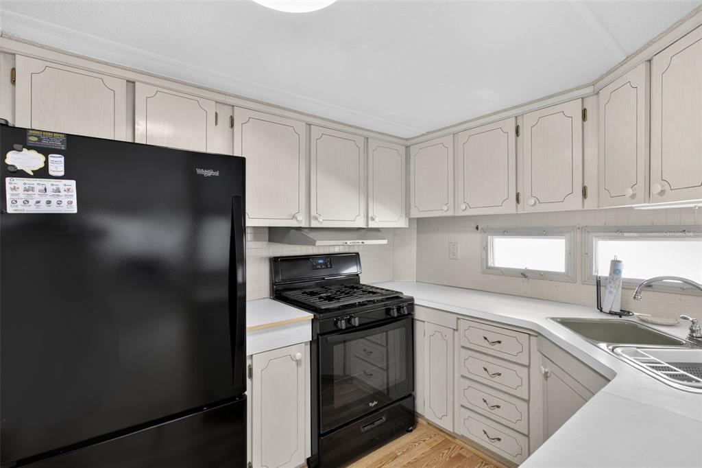 802 Turf Street Venice, FL 34285 - Photo 23 of 50 a kitchen with granite countertop white cabinets and refrigerator