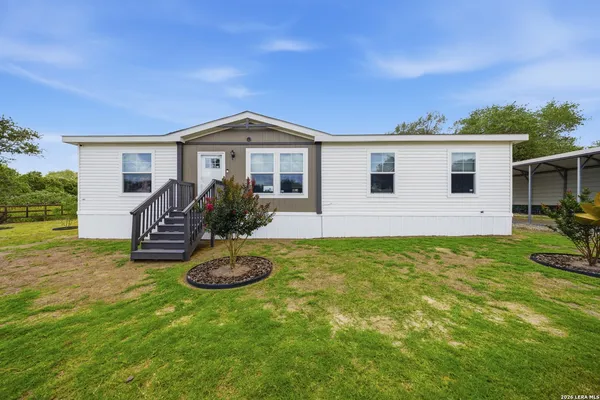 a front view of house with yard and outdoor seating
