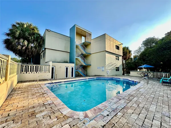 a view of a house with pool and sitting area