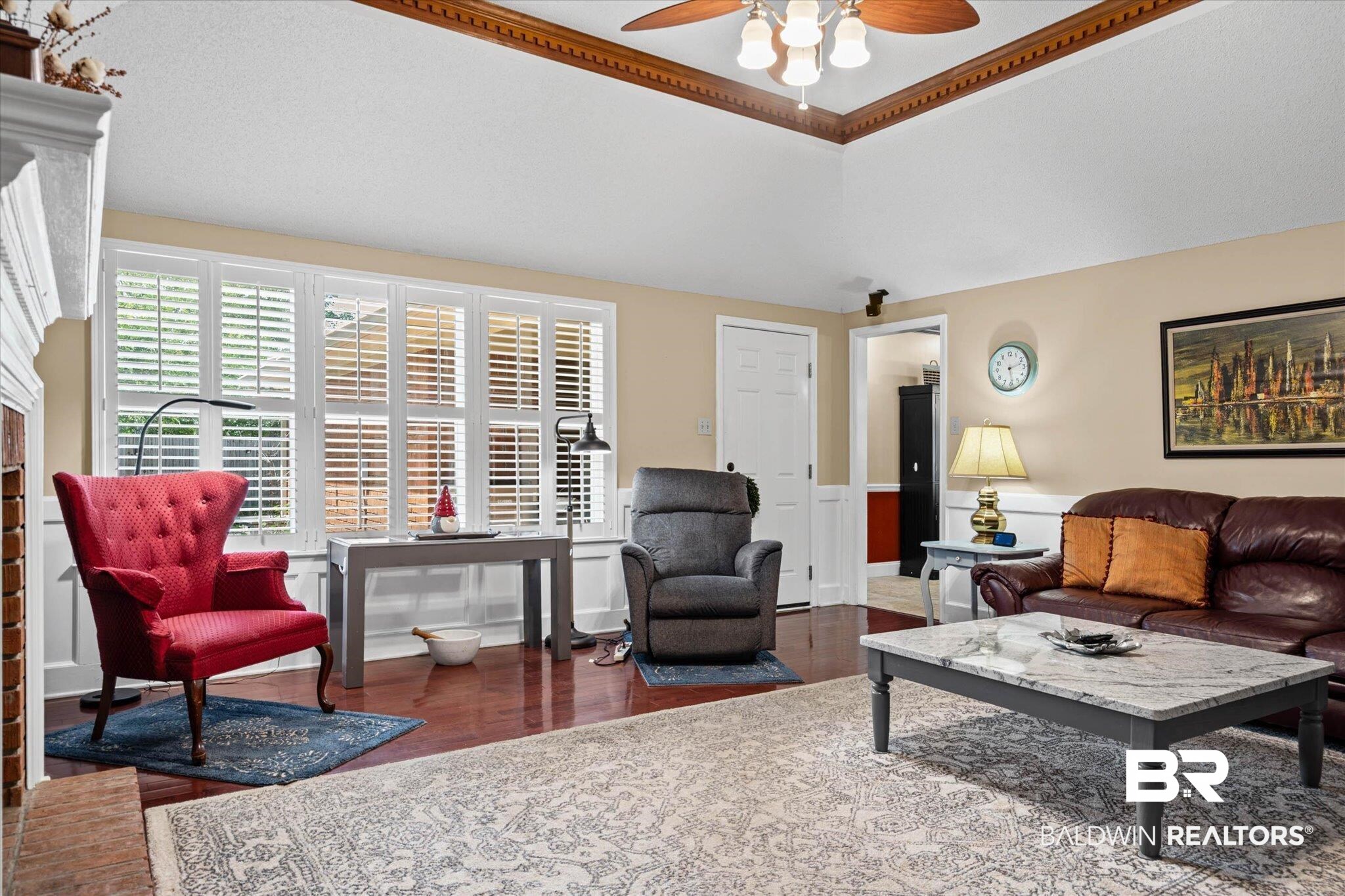 7410 Smithfield Road East Mobile, AL 36695 - Photo 6 of 24 Living area featuring hardwood flooring, wainscoting, and a vaulted ceiling with crown molding