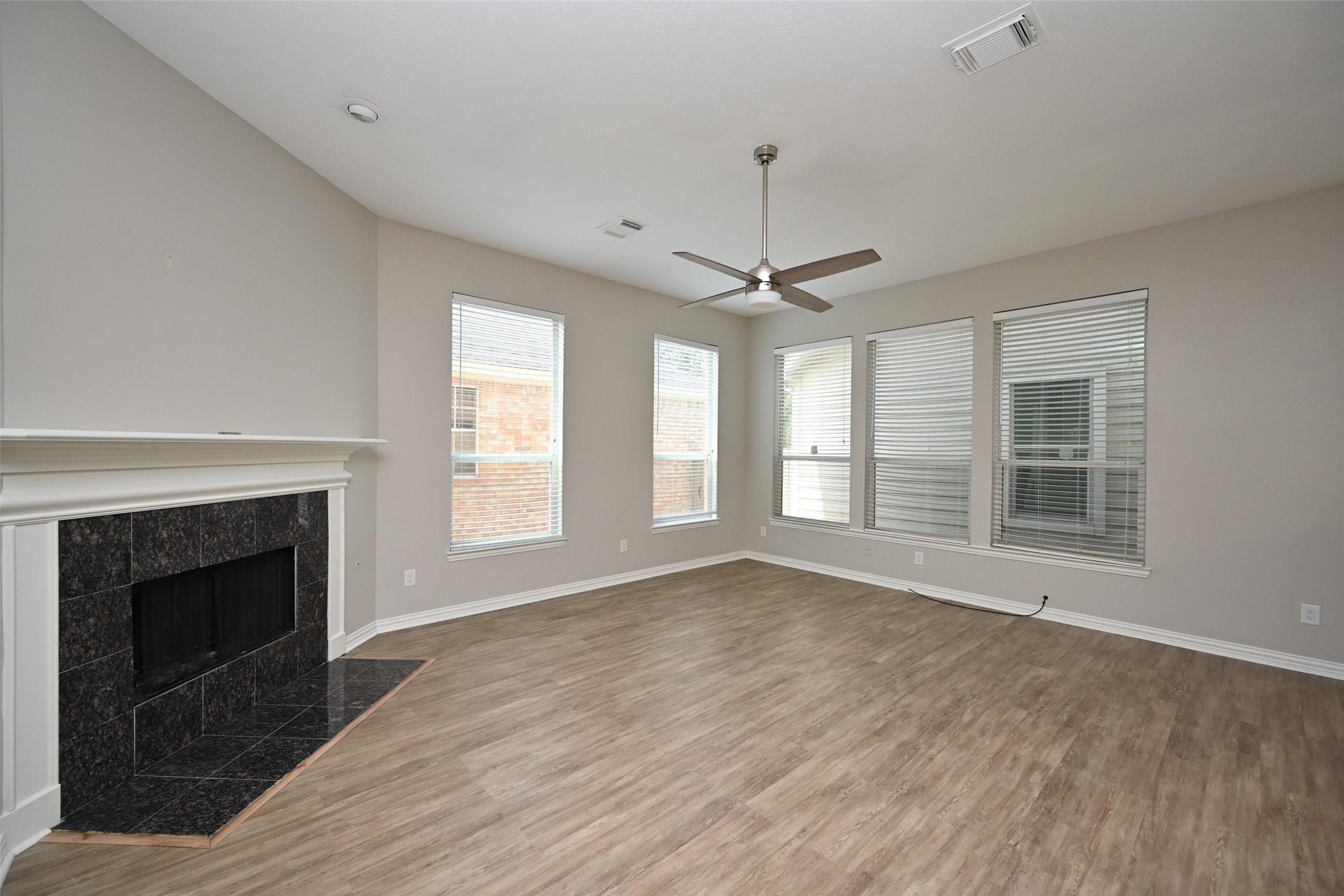 1502 Beaconshire Houston, TX 77077 - Photo 12 of 29 a view of an empty room with wooden floor fireplace and a window