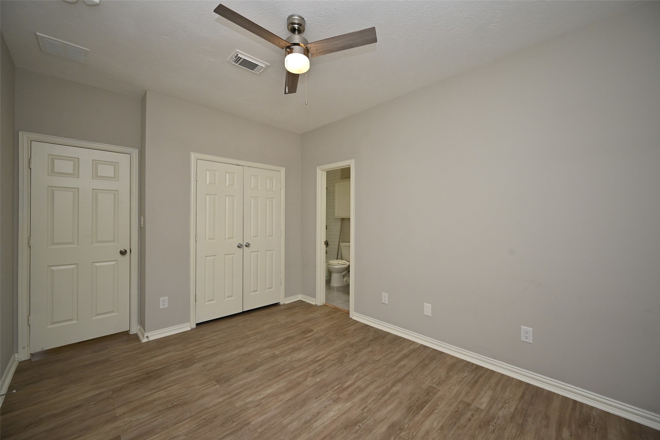 1502 Beaconshire Houston, TX 77077 - Photo 23 of 29 an empty room with wooden floor and ceiling fan