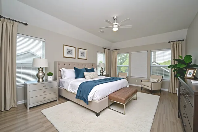 a spacious bedroom with a large bed and a chandelier