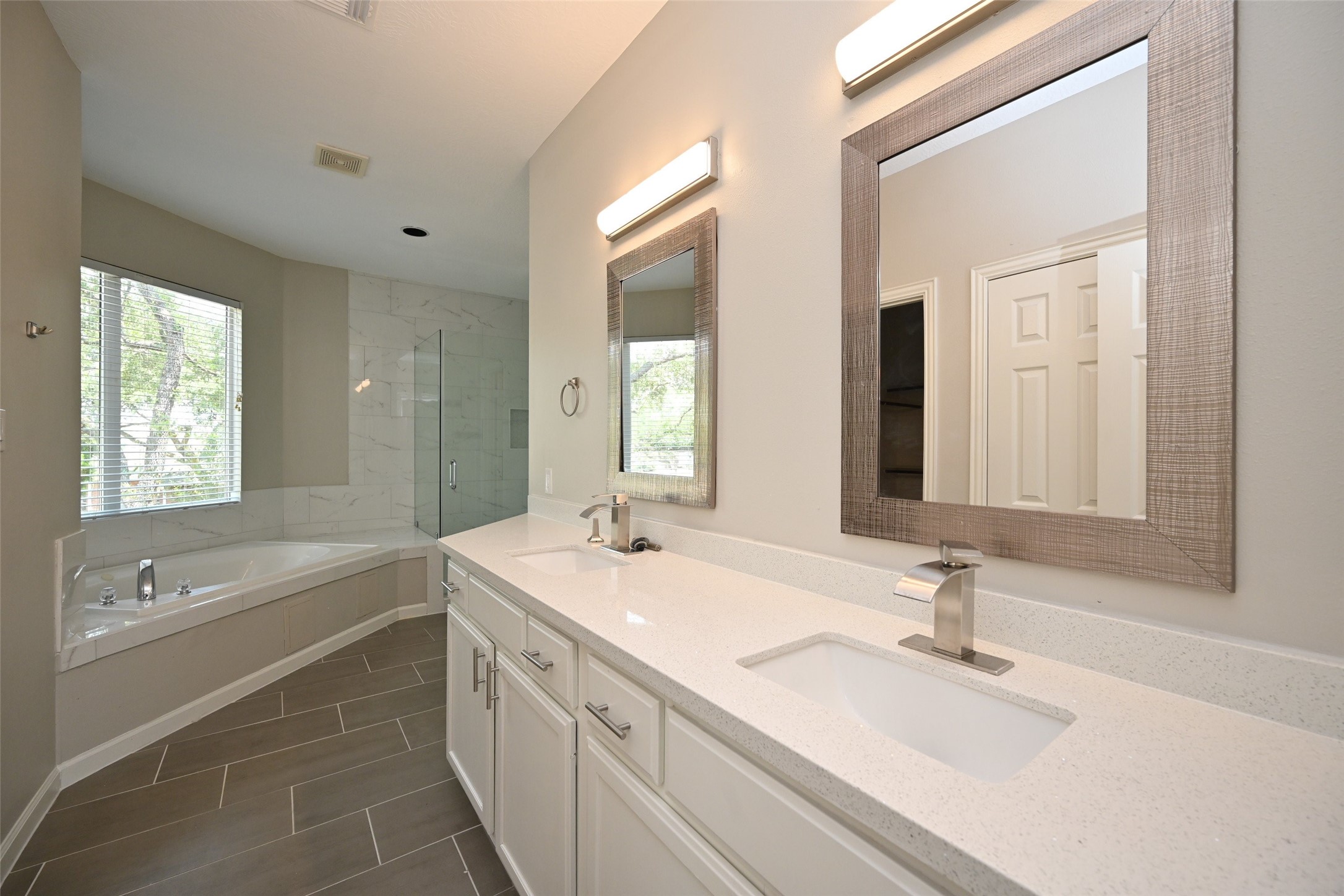 1502 Beaconshire Houston, TX 77077 - Photo 28 of 29 a bathroom with a double vanity sink large mirror and a bathtub