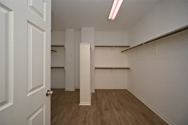 a view of walk in closet with wooden floor