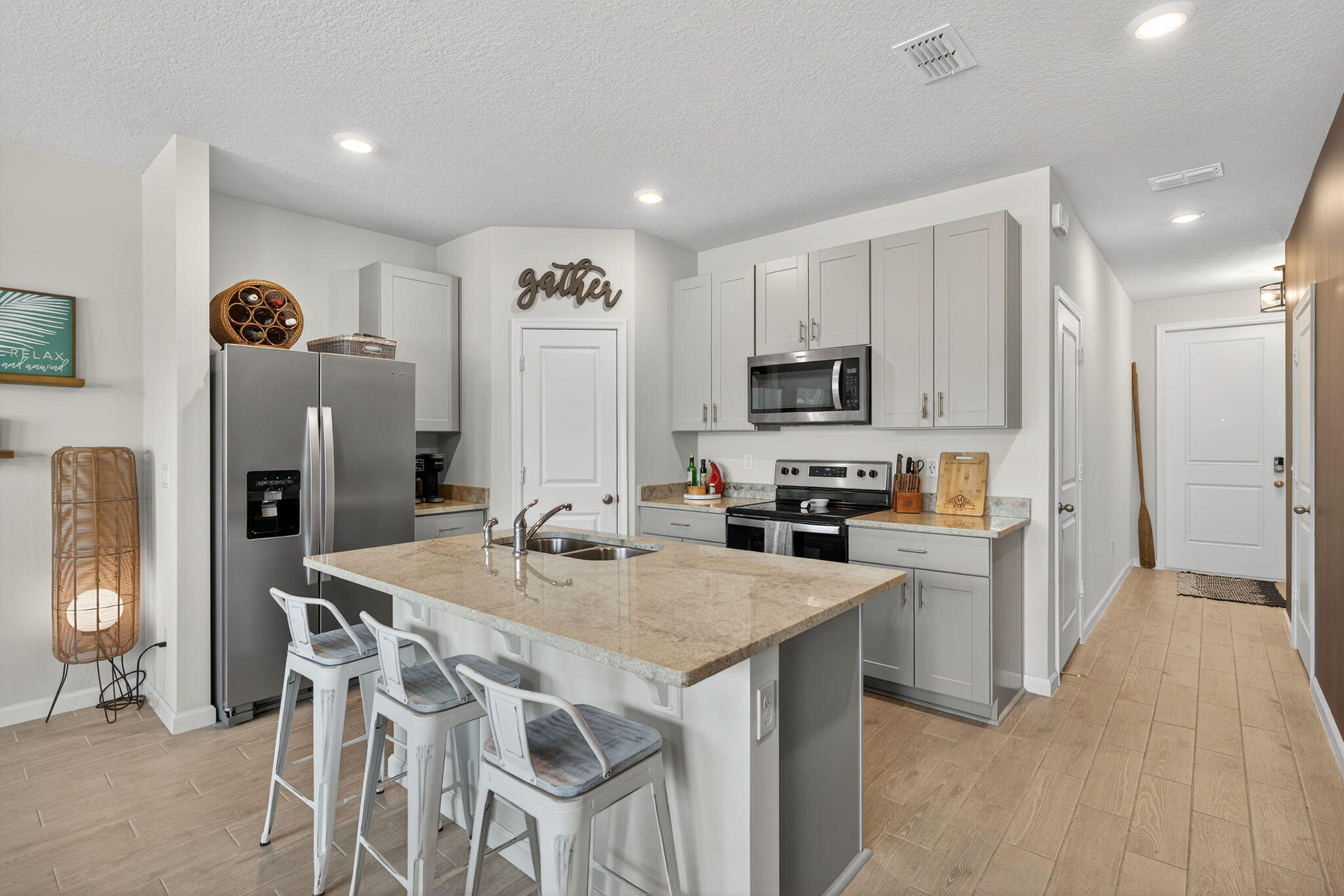 a kitchen with stainless steel appliances granite countertop a table chairs sink refrigerator and microwave