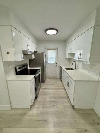 a kitchen with white cabinets and white appliances
