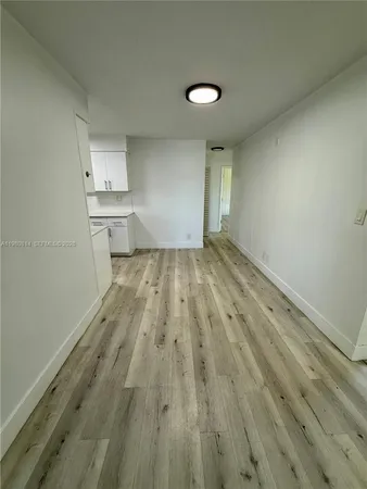 a view of a kitchen with wooden floor and a sink