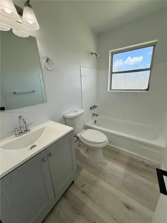 a bathroom with a double vanity sink mirror and toilet