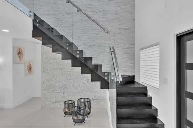 a large kitchen with kitchen island a large window a sink and stainless steel appliances