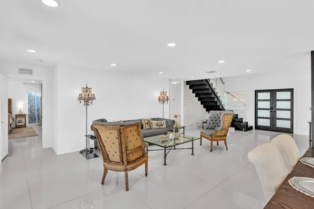 a living room with furniture flat screen tv and a large window