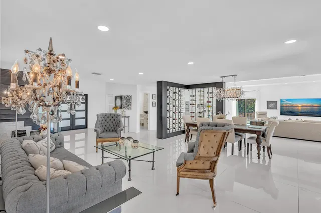 a living room with furniture a clock and a view of kitchen