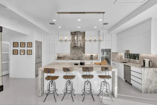 a view of a swimming pool with chairs and table in the patio