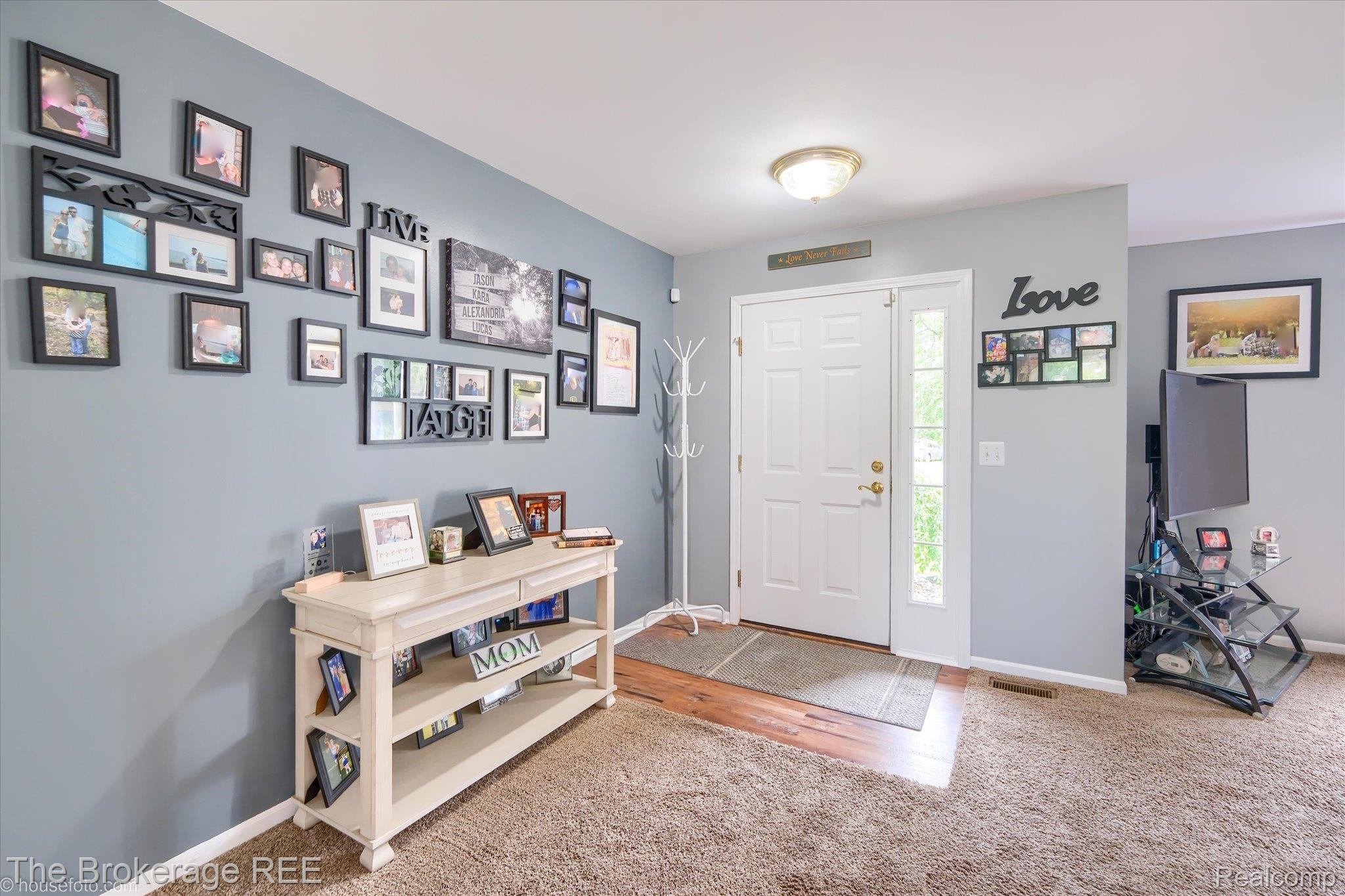 4432 North Belsay Road Flint, MI 48506 - Photo 30 of 79 Entryway featuring a white paneled door with sidelight, wood-finish flooring, and a flush mount ceiling light fixture