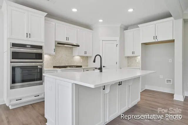 a kitchen with stainless steel appliances a sink stove and cabinets