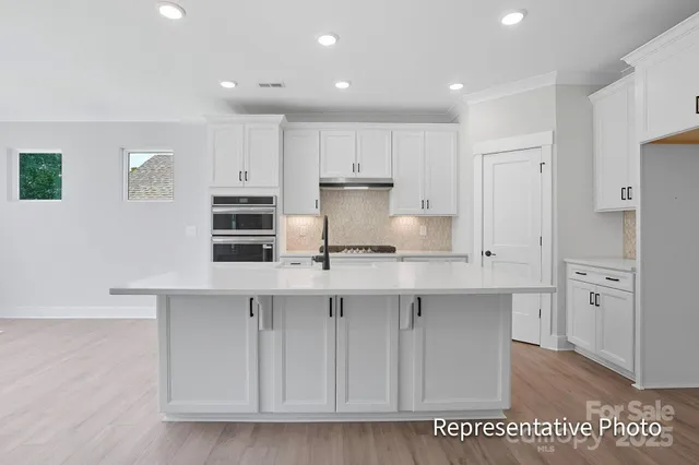a kitchen with white cabinets and refrigerator