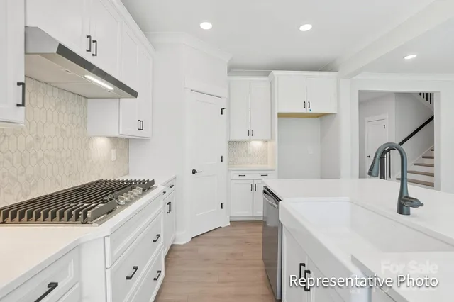 a kitchen with granite countertop a sink stove and cabinets