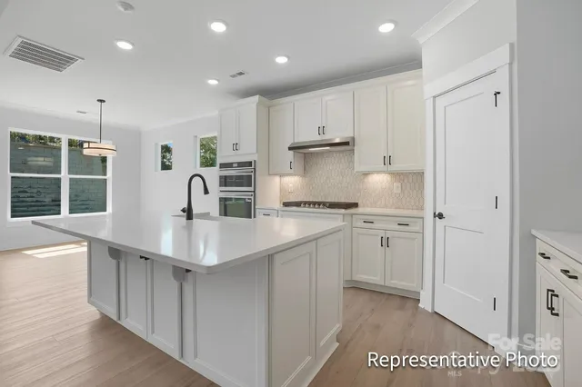 a kitchen with stainless steel appliances a sink stove and cabinets