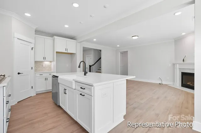 a kitchen with white cabinets and sink