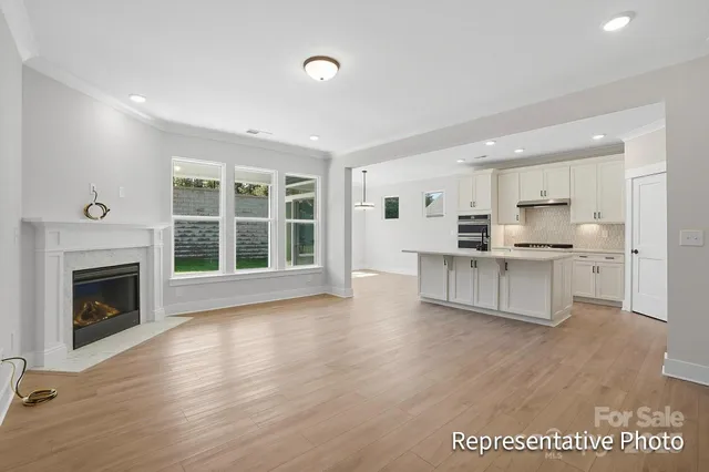 a large kitchen with stainless steel appliances kitchen island wooden cabinets and a fireplace