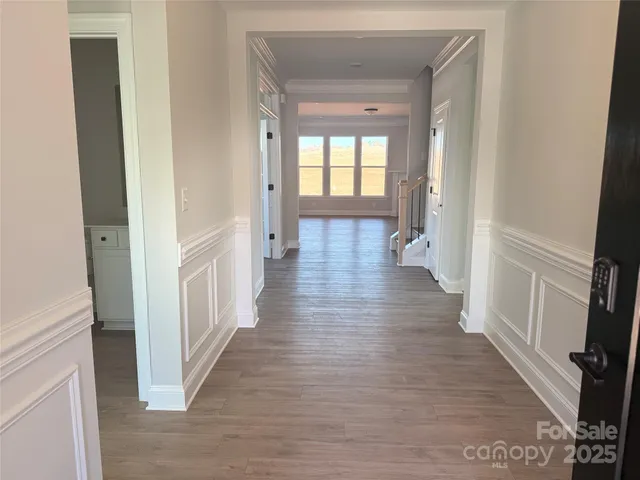 a view of a hallway with wooden floor and staircase