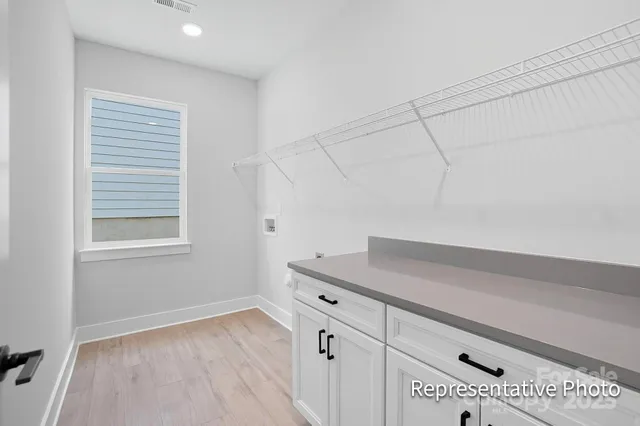 a kitchen with white cabinets and a wooden floor