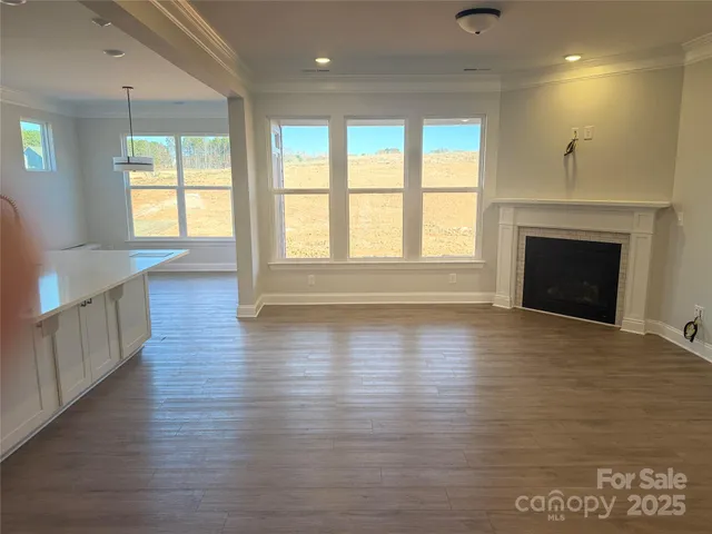 an empty room with wooden floor and fireplace
