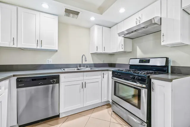 a kitchen with granite countertop white cabinets and white appliances